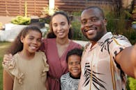 Smiling multicultural family enjoying time together outdoors in their garden.